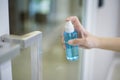 Woman is cleaning door handle with alcohol spray Royalty Free Stock Photo