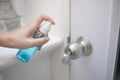 Woman is cleaning door handle with alcohol spray Royalty Free Stock Photo