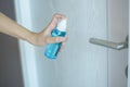 Woman is cleaning door handle with alcohol spray Royalty Free Stock Photo