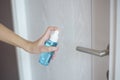 Woman is cleaning door handle with alcohol spray Royalty Free Stock Photo