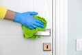 Woman cleaning a door handle with a disinfectant rag Royalty Free Stock Photo