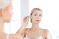 Woman cleaning ear with cotton swab at bathroom Royalty Free Stock Photo