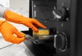 Woman cleaning electric oven with sponge in kitchen Royalty Free Stock Photo