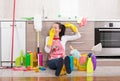 Woman with cleaning equipment and products on kitchen floor Royalty Free Stock Photo