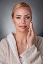 Woman cleaning face with cotton pad