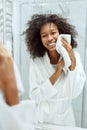 Woman cleaning face skin with white towel at bathroom portrait Royalty Free Stock Photo