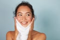 Woman cleaning facial skin with towel after washing face portrait