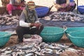 Woman cleaning fish before drying.