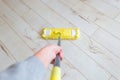 Woman cleaning floor with yellow mop at home. Microfiber mop isolated on white wooden floor background, closeup, indoors Royalty Free Stock Photo