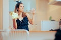 Woman Cleaning a Glass Using a Cloth in her Kitchen