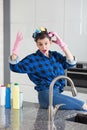 Woman IN a cleaning gloves sitting on a kitchen worktop