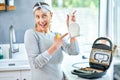 Woman cleaning grill or toaster machine in the kitchen