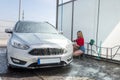 woman cleaning her car with hose with spray foam and pressured water manual car washing from dirt Royalty Free Stock Photo