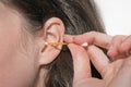 Woman cleaning her ear with plastic stick