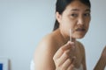 Woman cleaning her ears with cotton bud in bedroom,Female using cotton stick Royalty Free Stock Photo