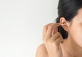 Woman cleaning her ears with cotton bud in bedroom,Female using cotton stick Royalty Free Stock Photo