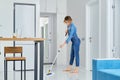 Woman cleaning her flat with mop