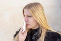 Woman cleaning her nose in winter