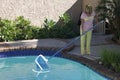 Woman cleaning her swimming pool