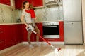 Woman cleaning house with wireless vacuum cleaner.