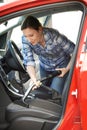 Woman Cleaning Inside Of Car Using Vacuum Cleaner