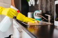 Woman cleaning kitchen cabinets with sponge and spray cleaner Royalty Free Stock Photo