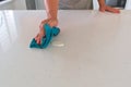 Woman cleaning kitchen countertop.