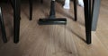 Woman cleaning living room with modern white vacuum cleaner point of view from under the table. Royalty Free Stock Photo