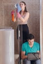 Woman is cleaning, and man is working on a laptop Royalty Free Stock Photo