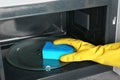 Woman cleaning microwave oven with sponge Royalty Free Stock Photo