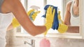 Woman cleaning mirror in bathroom Royalty Free Stock Photo