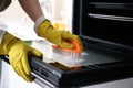 Woman cleaning oven door with baking soda in kitchen, closeup Royalty Free Stock Photo