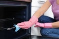 Woman cleaning oven rack with rag in kitchen Royalty Free Stock Photo