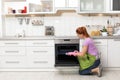 Woman cleaning oven tray with rag Royalty Free Stock Photo
