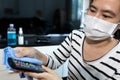 Woman is cleaning the remote control of TV,wiping the things in a house with disinfectant,alcohol antiseptic,disinfecting the