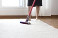 Woman cleaning rug carpet with vacuum cleaner at home Royalty Free Stock Photo