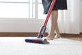 Woman cleaning rug carpet with vacuum cleaner at home Royalty Free Stock Photo