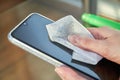 Woman is cleaning a smartphone with a jet of alcohol aerosol hand sanitizer and disposable cloth at home. Precautions regarding