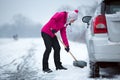 Woman cleaning snow around her car Royalty Free Stock Photo