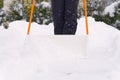 Woman cleaning snow with shovel in winter day. Woman shovelling snow walkway in front of house