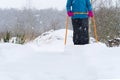 Woman cleaning snow with shovel in winter day. Woman shovelling snow walkway in front of house