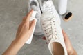 Woman cleaning stylish footwear on grey marble background, closeup. Shoe care accessories Royalty Free Stock Photo