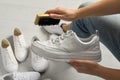 Woman cleaning stylish footwear indoors, closeup. Shoe care accessory Royalty Free Stock Photo