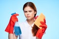 woman with cleaning supplies in the hands of professional service delivery blue background