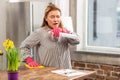 Woman cleaning table and sneezing having allergy to dust Royalty Free Stock Photo