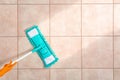 Woman cleaning tile floor with mop, top view.