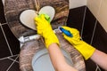 Woman is cleaning toilet bowl with a rag and disinfectant Royalty Free Stock Photo