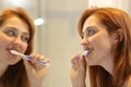 Woman cleaning tooth using a brush in the bathroom