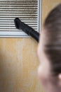 Woman cleaning ventilation grill with vacuum cleaner. Royalty Free Stock Photo