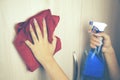 Woman during cleaning white bookstand at home